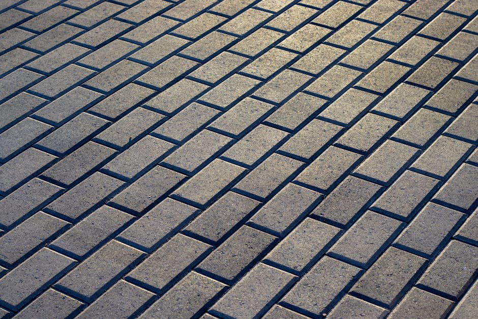 Sunlit outdoor stone pavement with a uniform brick pattern, ideal for backgrounds and architecture projects.